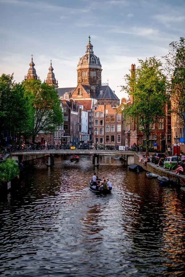 A canal in Amsterdam with the Sint-Nicolaaskerk behind it